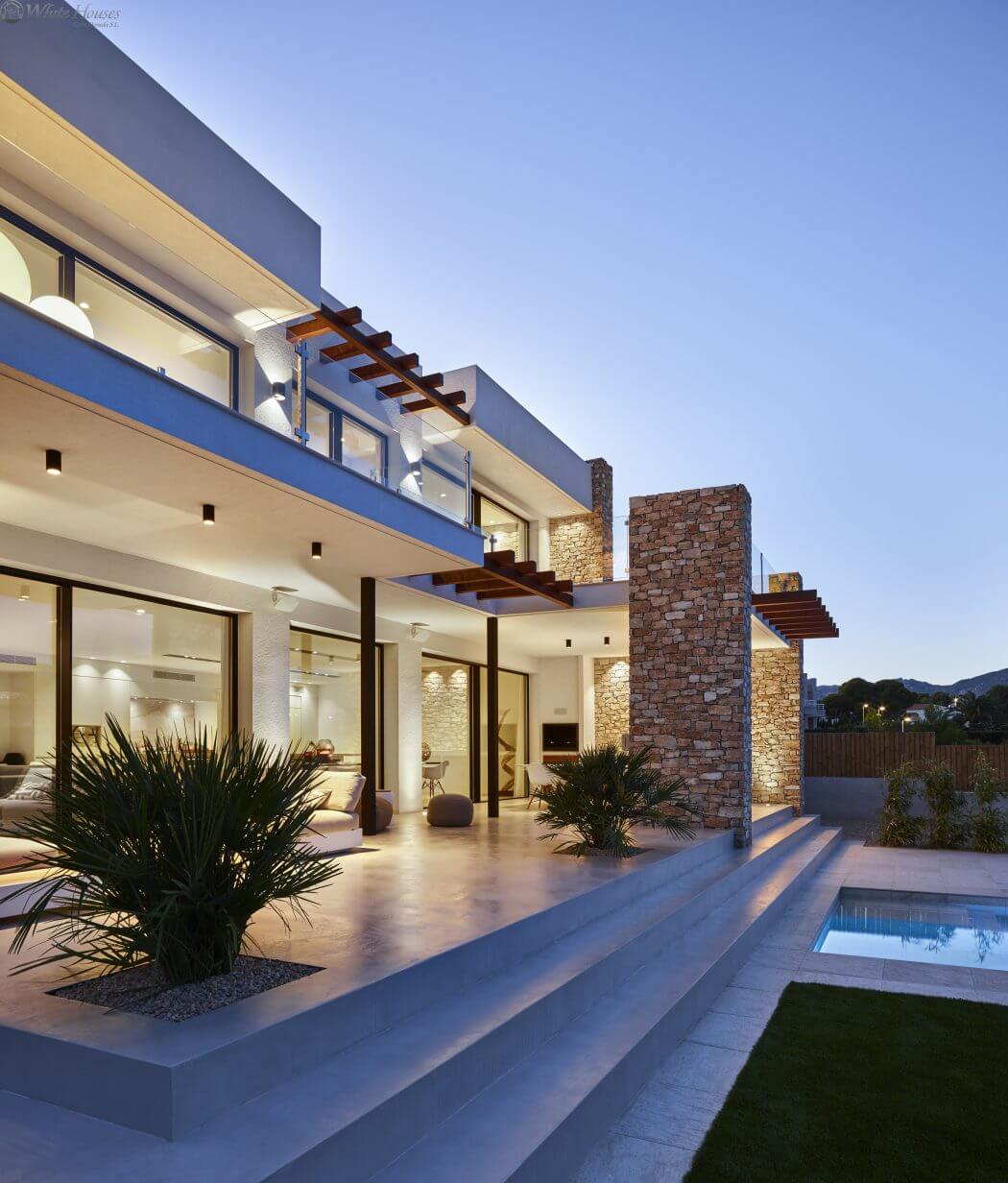 Sleek modern architecture with stone accents, pool, and outdoor decor.