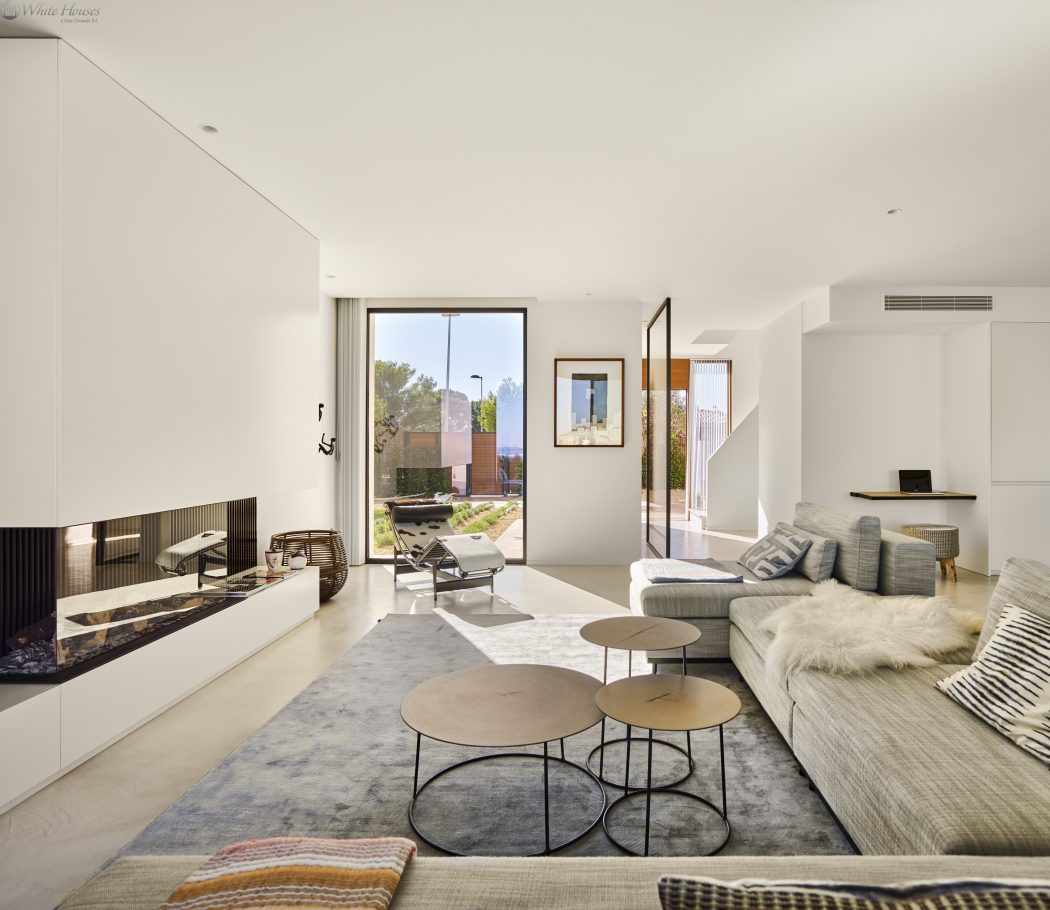 Spacious, open-concept living room with contemporary furniture and large windows overlooking exterior.