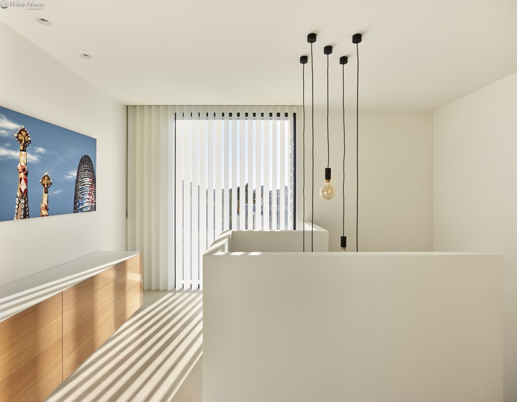 Minimalist modern interior with clean lines, vertical blinds, and striking pendant lighting.