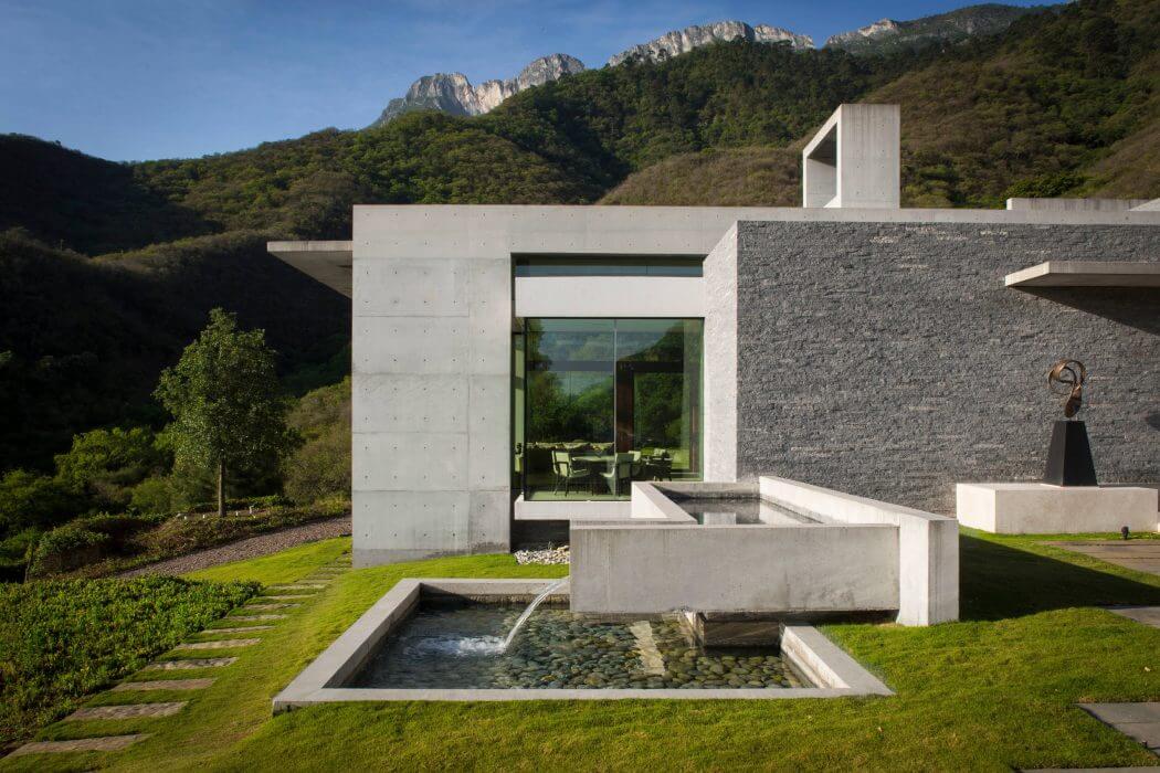 A modern, minimalist structure with a sleek glass facade and a tranquil water feature.