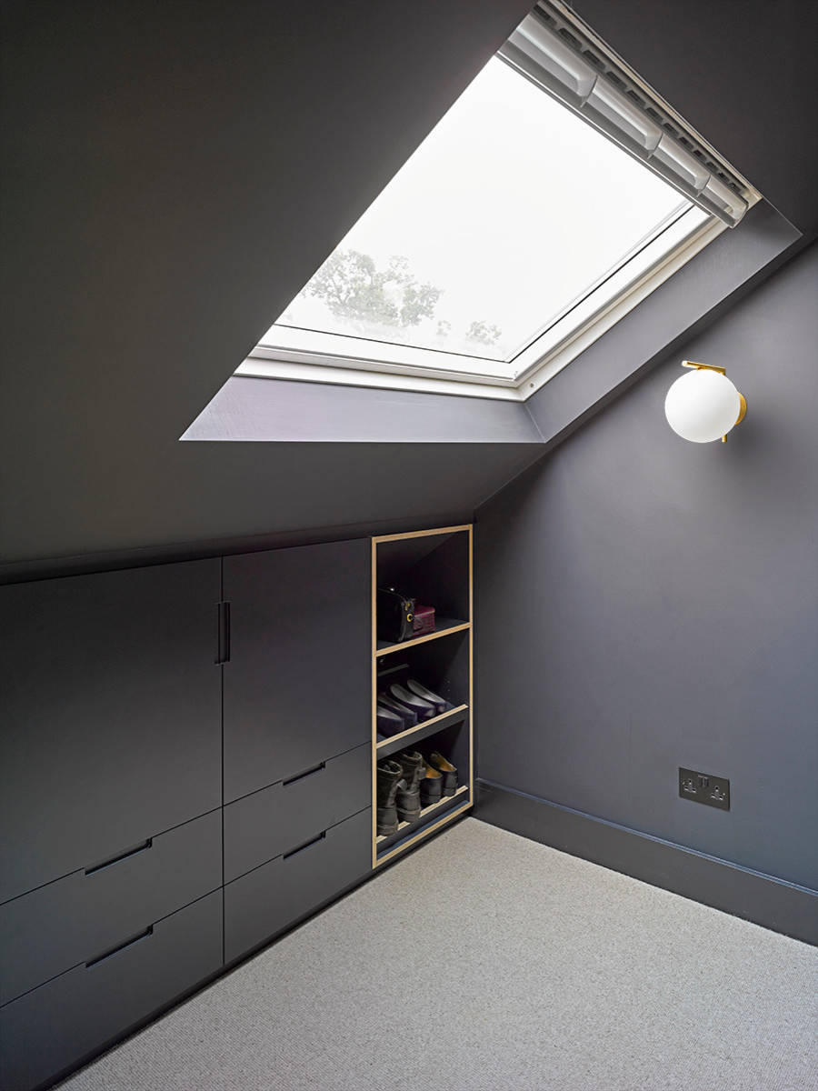 Modern attic space with sleek built-in storage, skylight, and minimalist lighting.