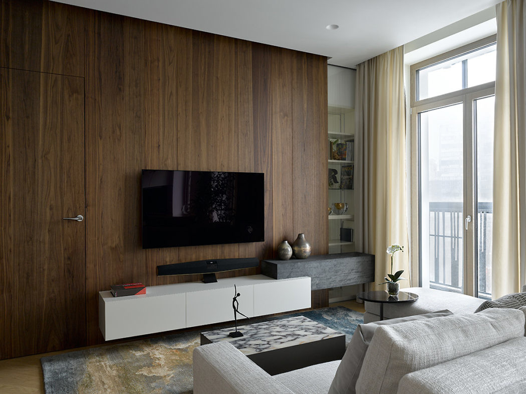 Contemporary living room with wooden wall paneling and minimalist decor.