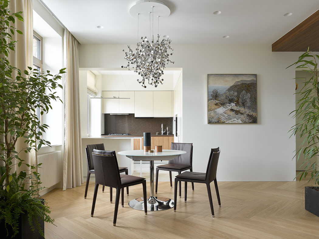 Modern dining room with table, chairs, and an open kitchen.