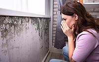 Shocked Woman Looking At Mold On Wall