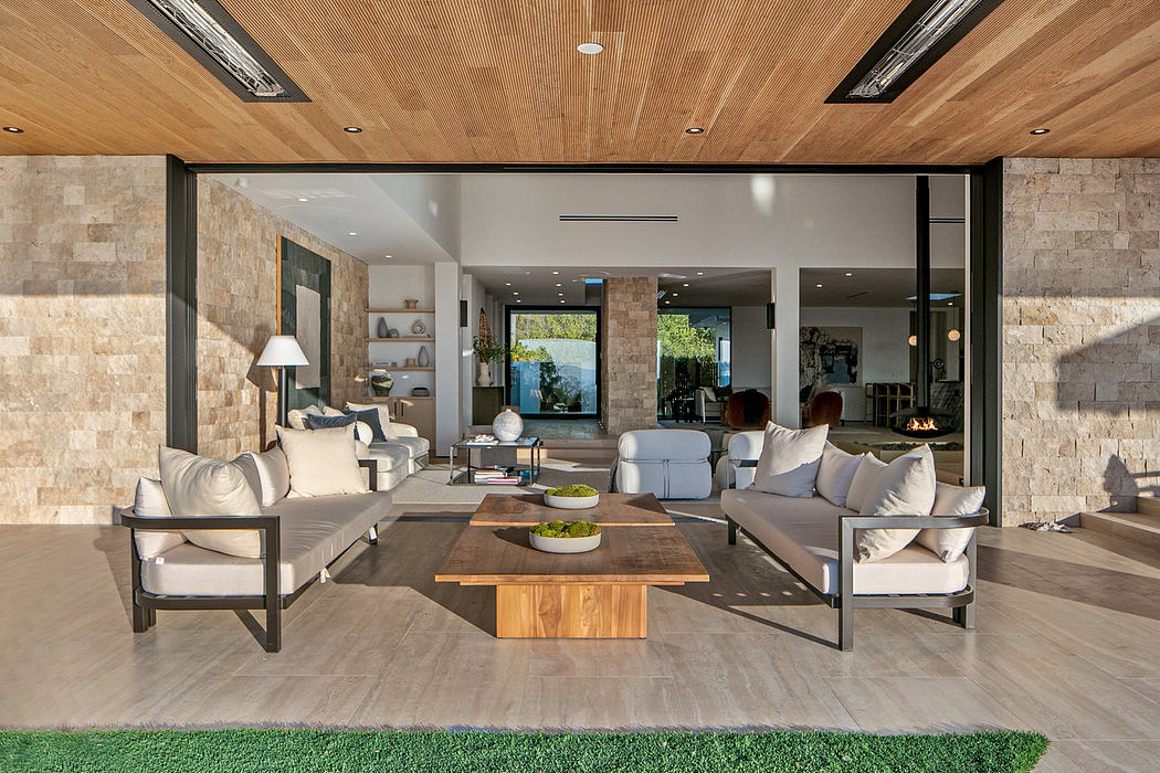Modern living room with sliding glass doors, wooden ceiling, and minimalistic furniture.