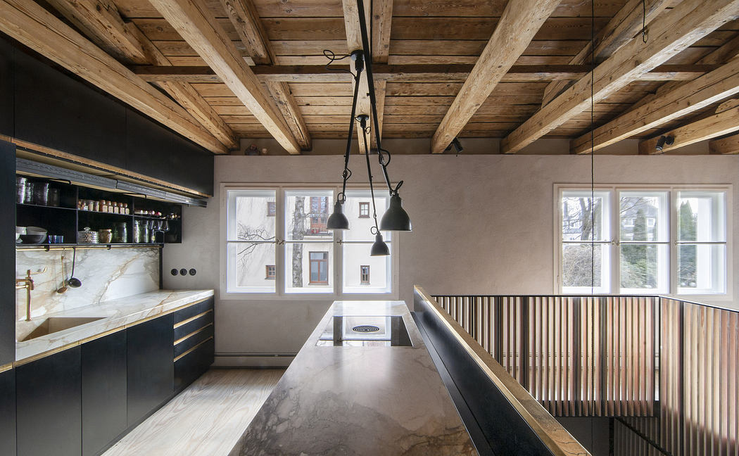 Modern kitchen with exposed beams, pendant lights, and sleek black cabinetry.