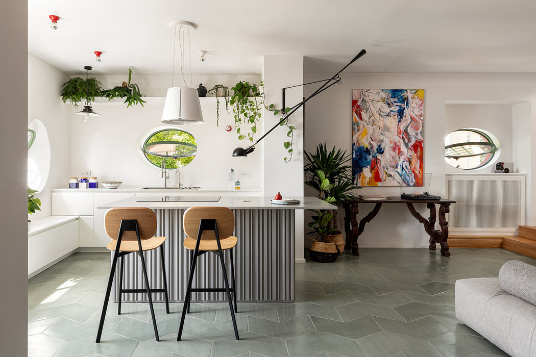 Modern kitchen with bar stools, pendant lights, and vibrant art.