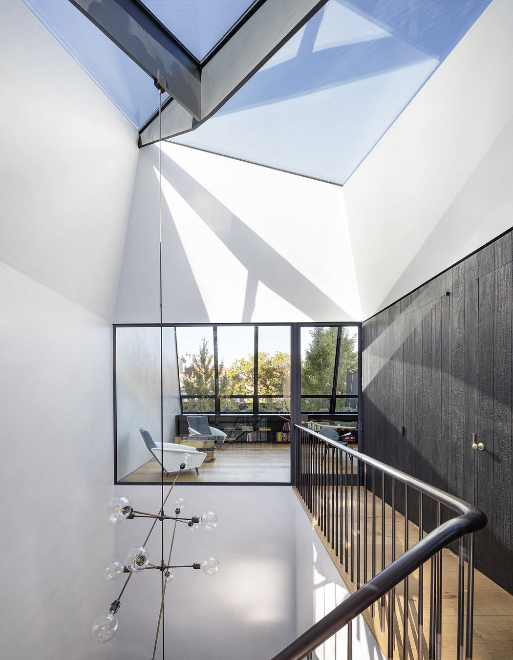 Modern stairwell with geometric skylight and minimalist design.