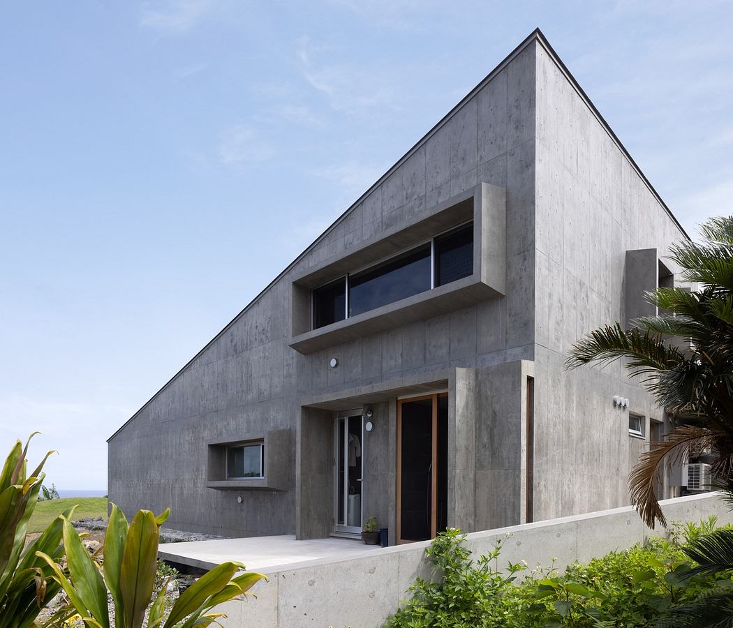 Modern concrete house with geometric design and ocean view.