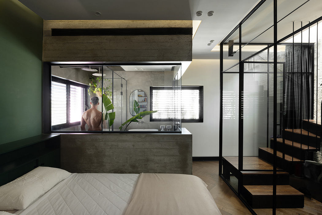 Modern bedroom with a glass-walled bathroom and sleek, minimalist decor.