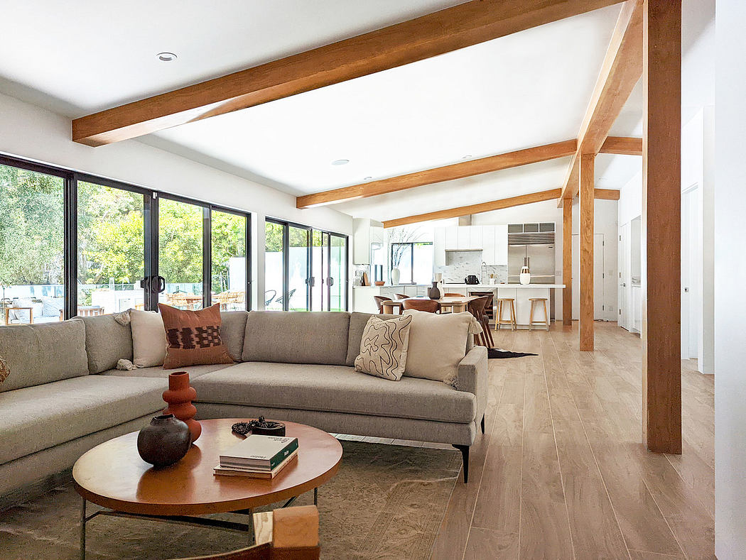Modern living room with large windows and wooden beams.