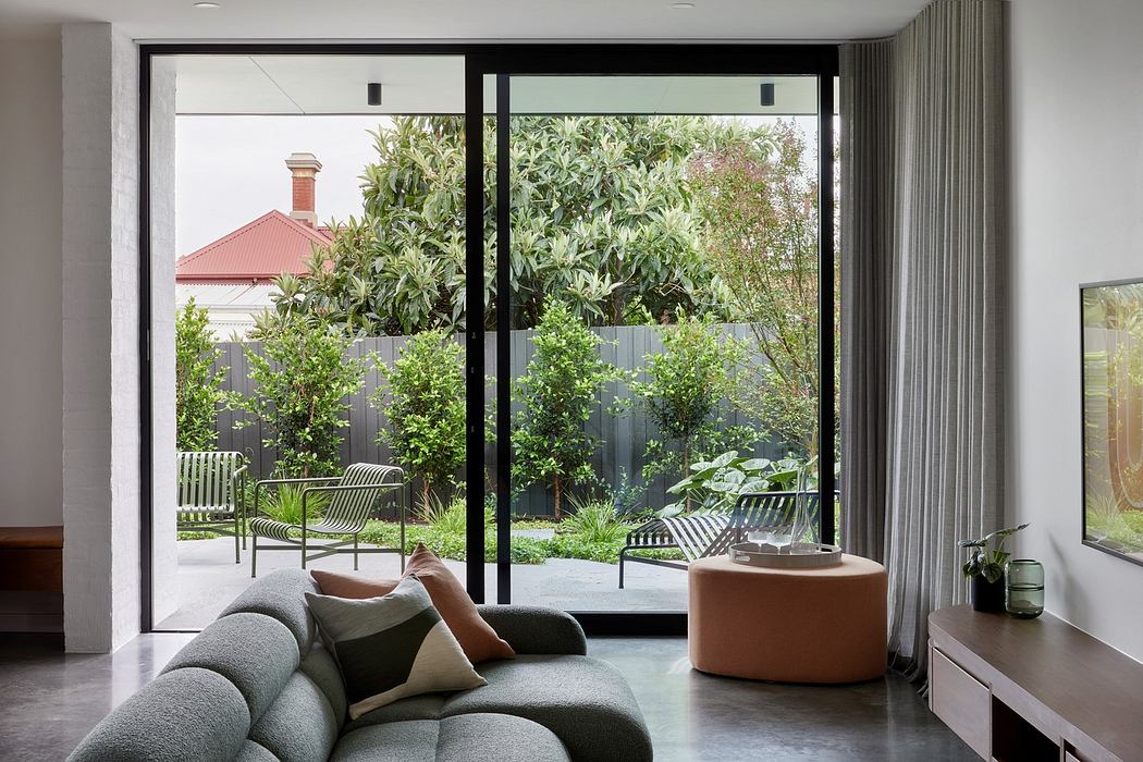Modern living room with floor-to-ceiling windows overlooking a garden.