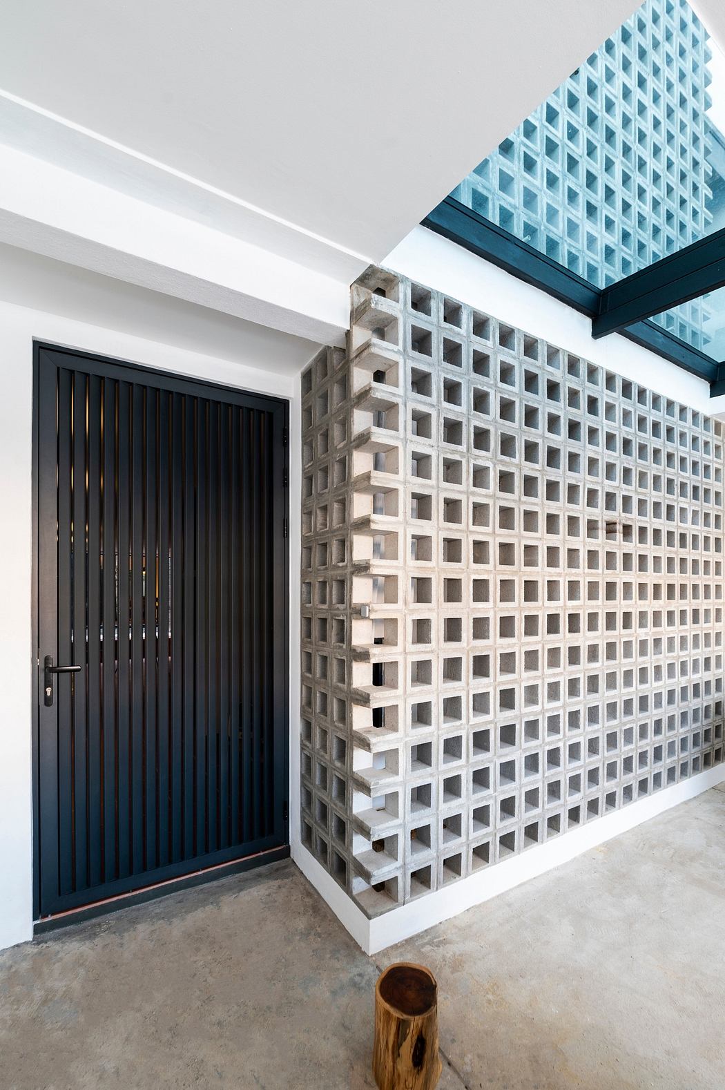 Modern room with a decorative concrete block wall and a sleek black door.