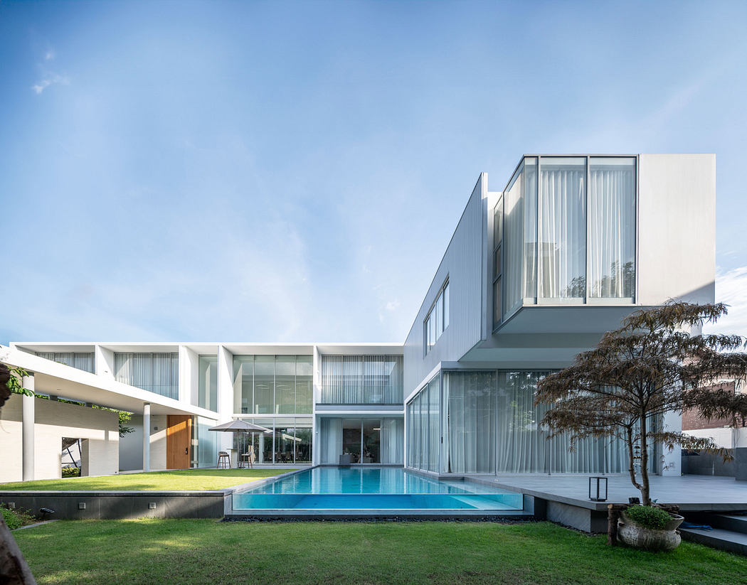 Modern white house with large windows and a swimming pool.