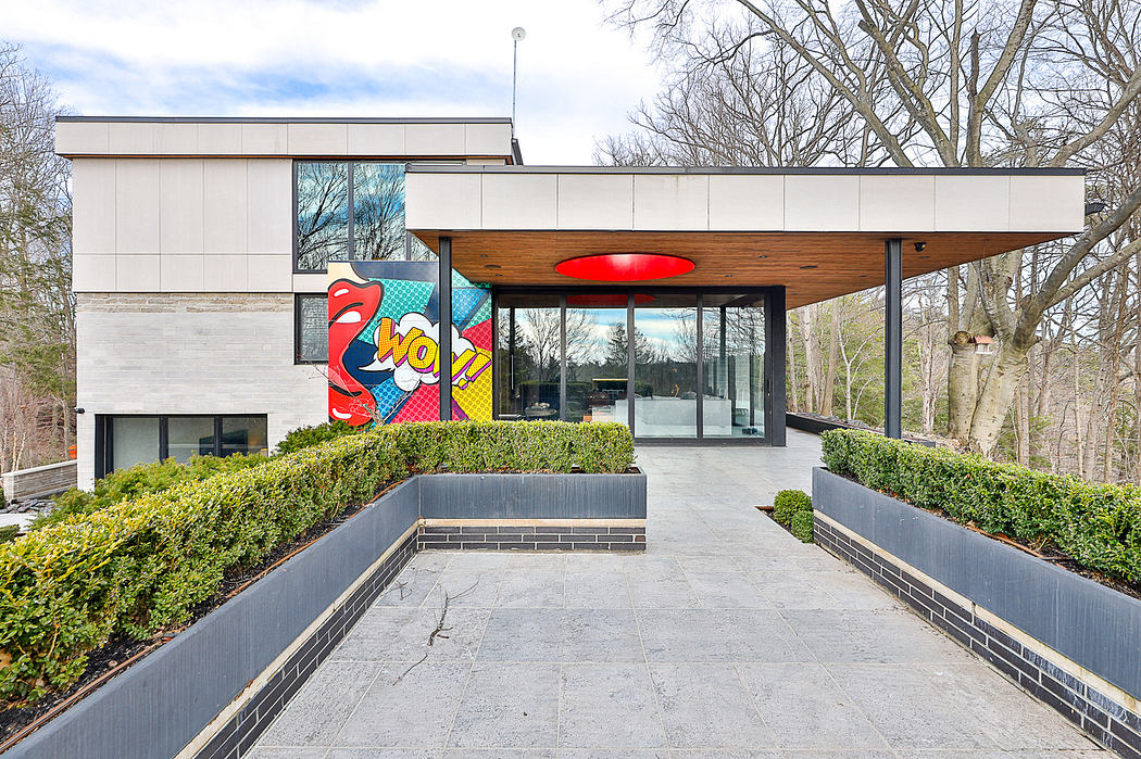 Modern house entrance with large glass doors and colorful pop art mural.