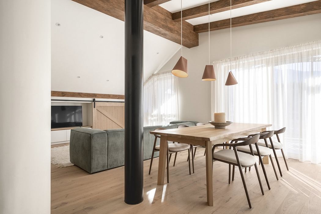 Modern dining room with wooden table, chairs, and exposed beams, accented by