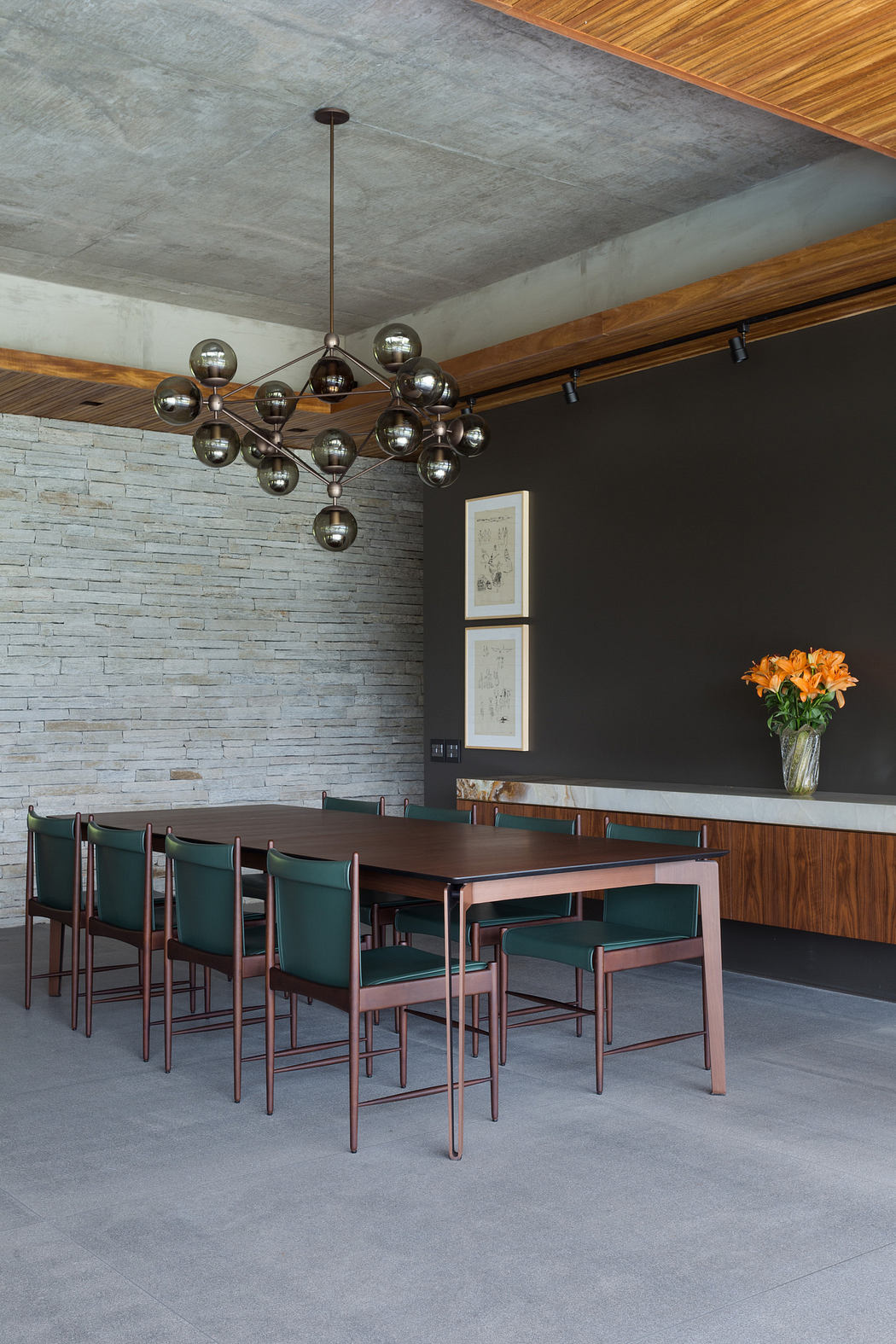 Modern dining room with a Sputnik chandelier, brick wall, and wooden