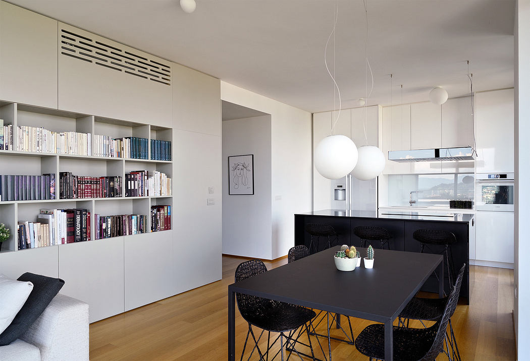 Modern dining room with bookshelf, black table, and pendant lights.