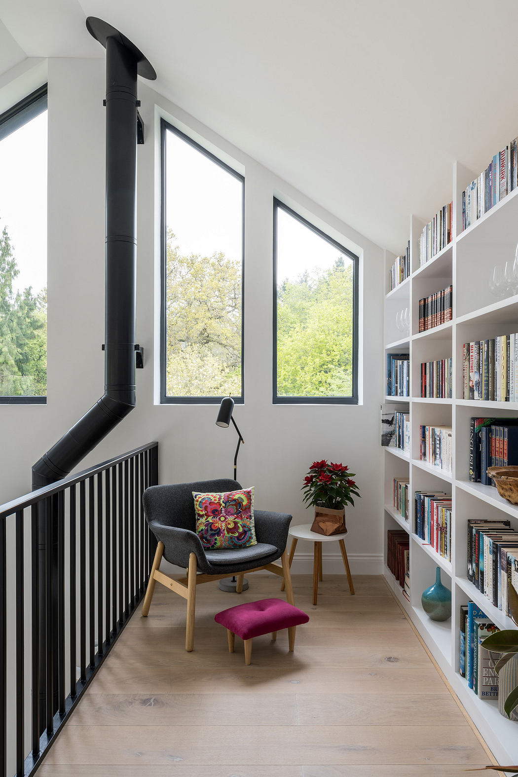 Modern reading nook with floor-to-ceiling bookshelves, armchair,