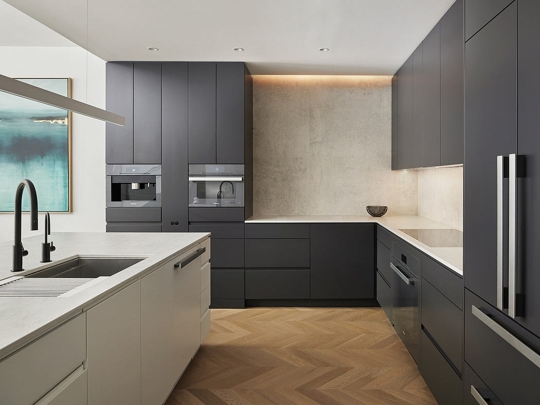 Modern kitchen with dark cabinets, integrated appliances, and herringbone wood floor.