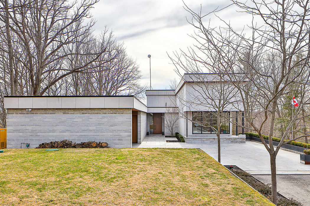 Modern home exterior with clean lines, flat roof, and bare trees.