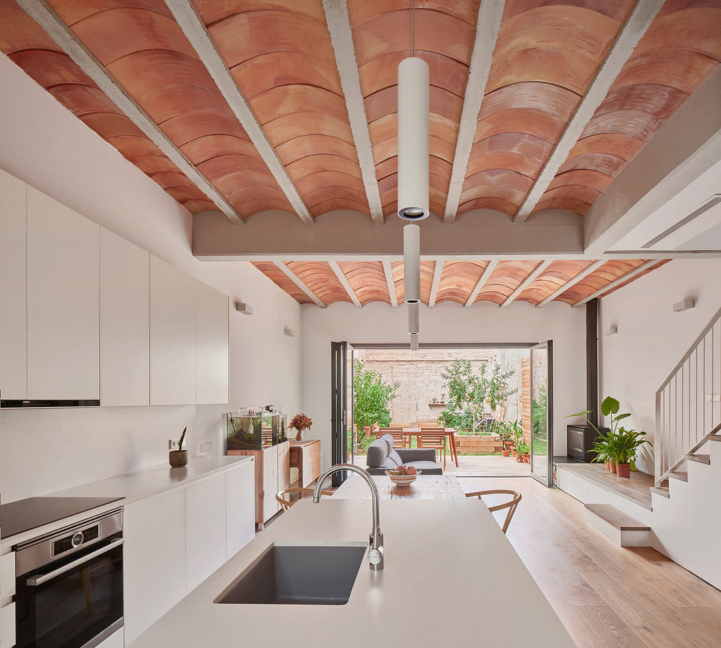 Modern kitchen with white cabinets, terracotta ceiling vaults, and a view