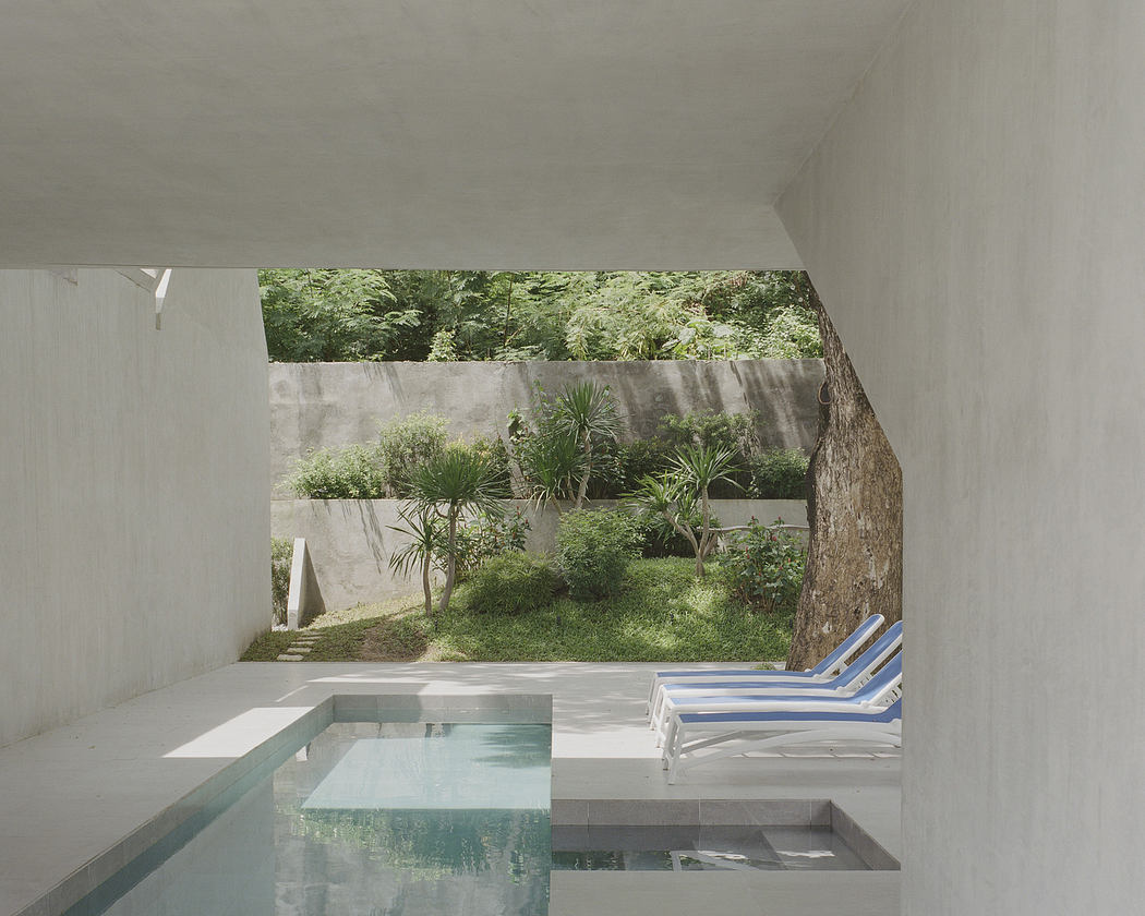 Modern minimalist indoor pool with garden view.