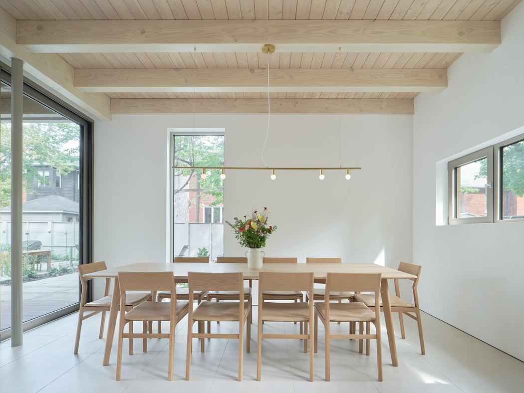 Minimalist dining room with wooden table, chairs, and exposed beams.