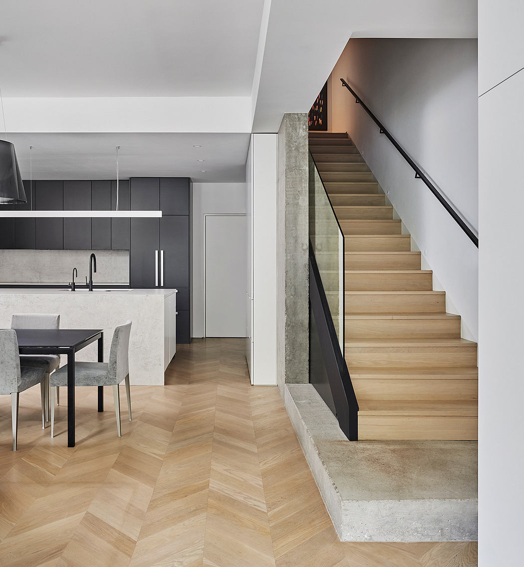 Modern kitchen interior with wood floors and staircase.