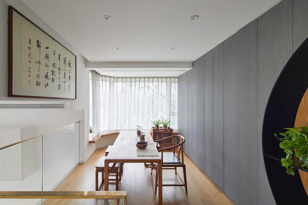 Modern dining room with wooden table, gray walls, and minimal decor.