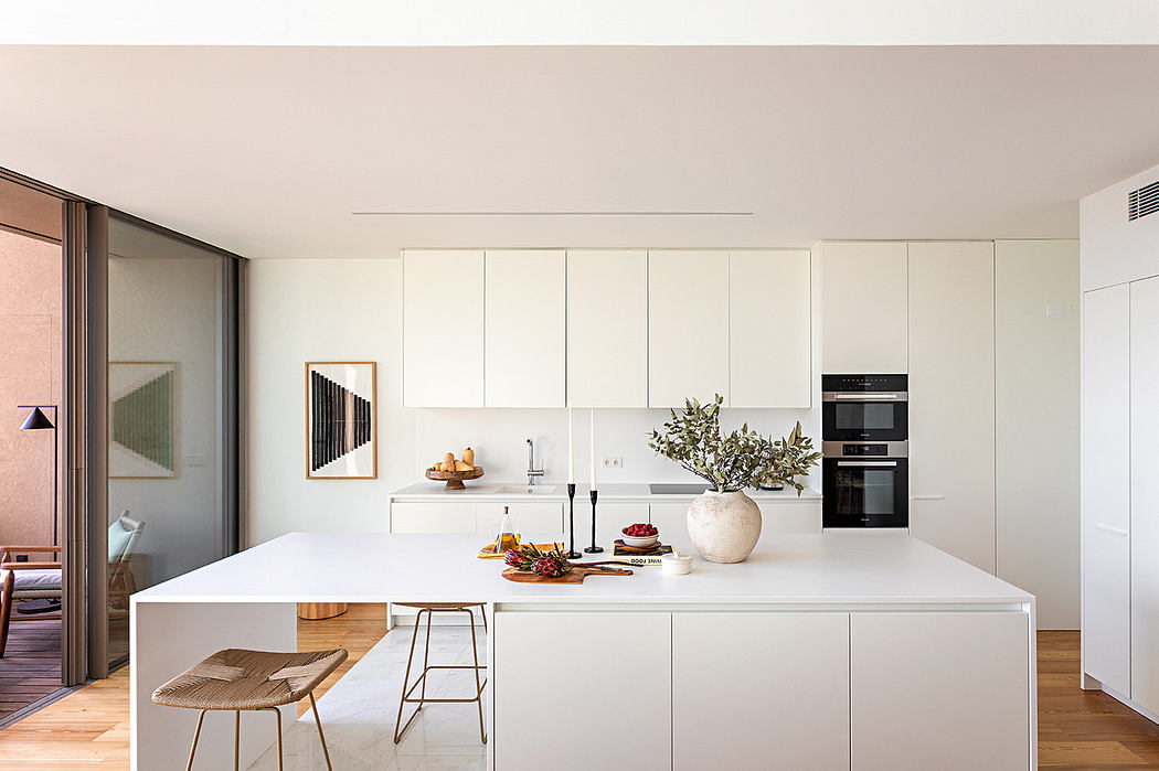 Minimalist modern kitchen with white cabinetry and central island.