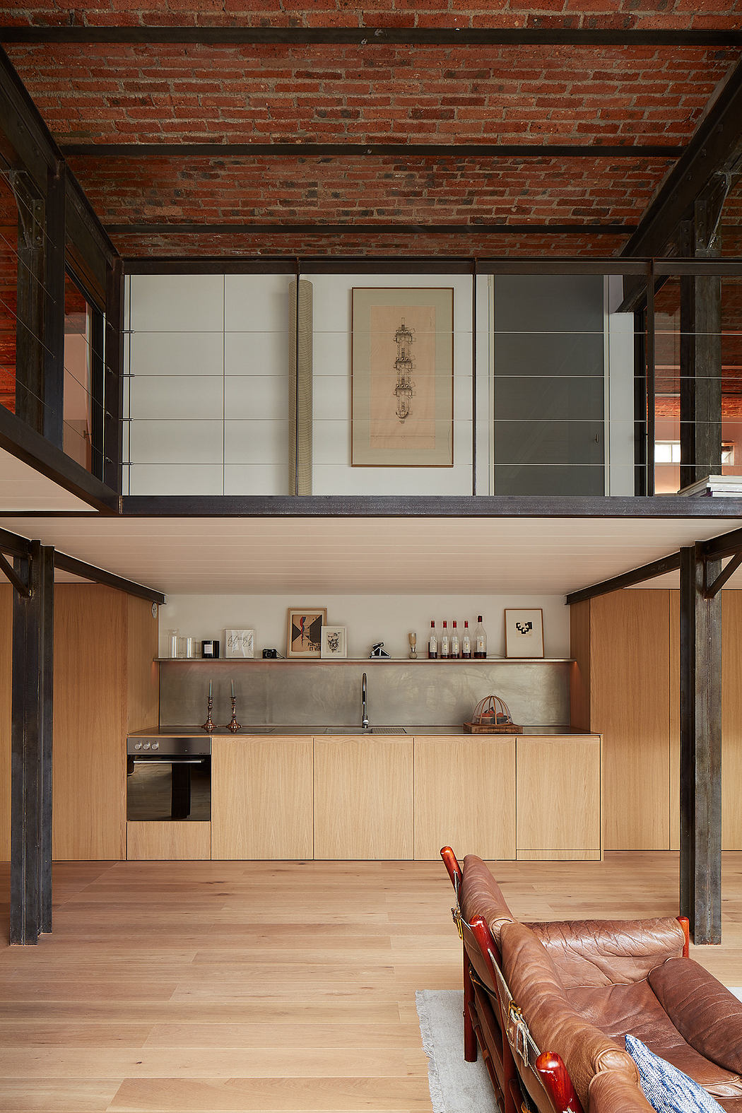 Modern loft interior with exposed brick, wooden floors, and a sleek kitchen.