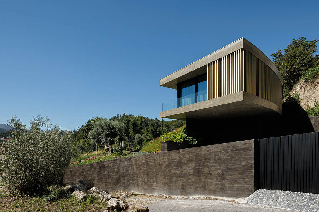 Modern cantilevered house with wooden slats over a concrete base in a