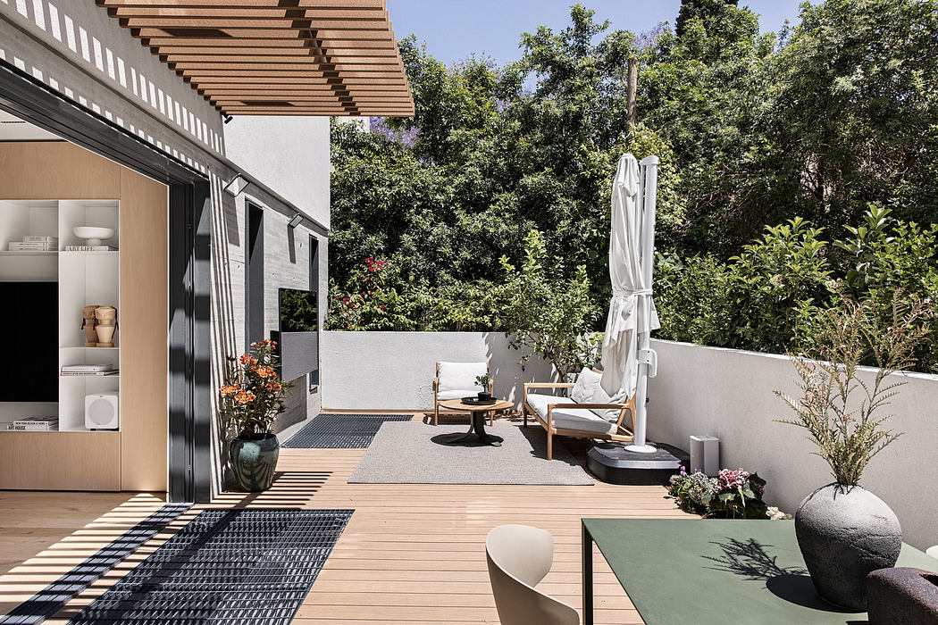 Modern patio design with wooden decking, outdoor furniture, and lush greenery.