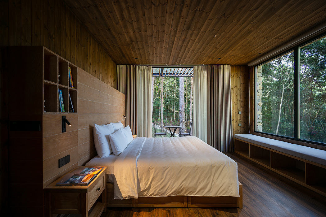 Modern wooden bedroom with large window overlooking a forest.