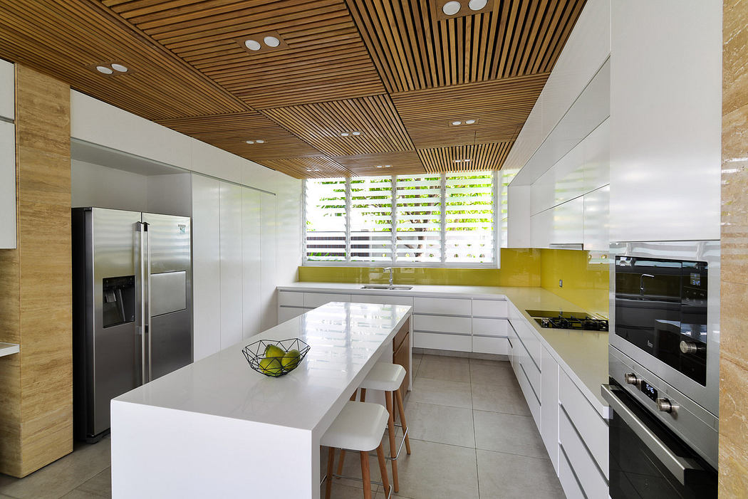 Modern kitchen with wooden ceiling, white countertops, and stainless steel appliances.