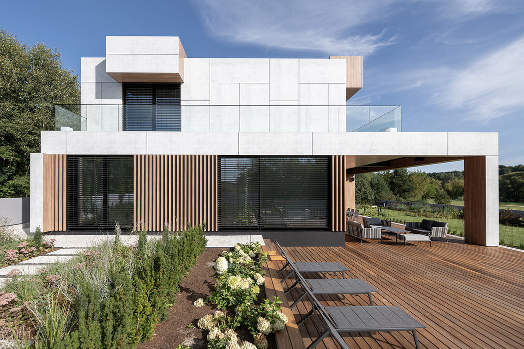 Modern house with large windows, wooden slats, and a deck with outdoor seating