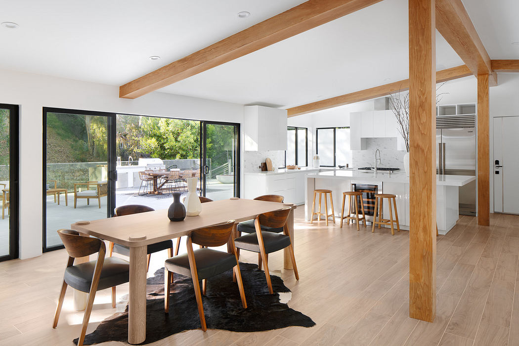 Modern kitchen and dining area with large windows and wooden accents.
