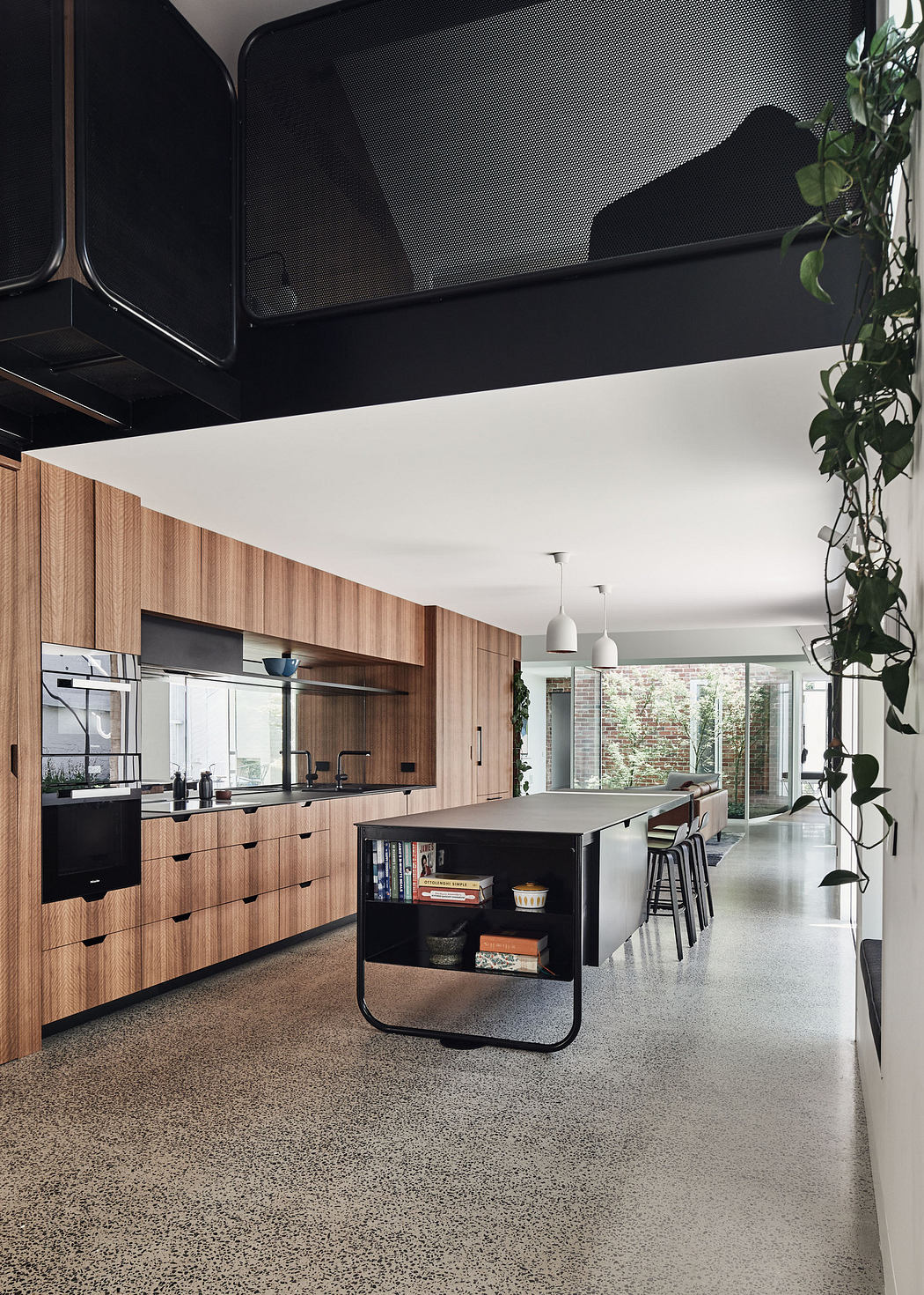 Modern kitchen interior with wooden cabinetry and terrazzo flooring.