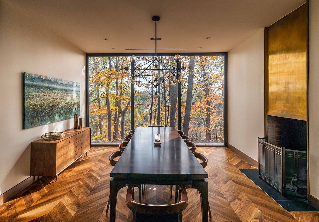 Modern dining room with large window overlooking autumn trees.