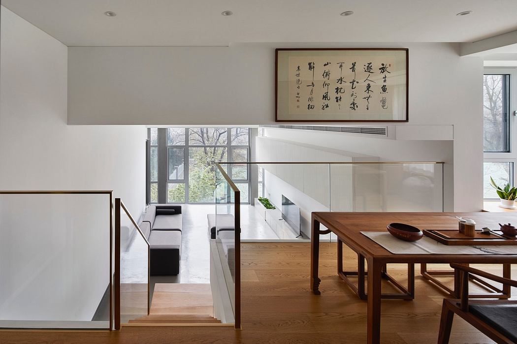 Modern interior with wooden floors, dining table, and calligraphy artwork.