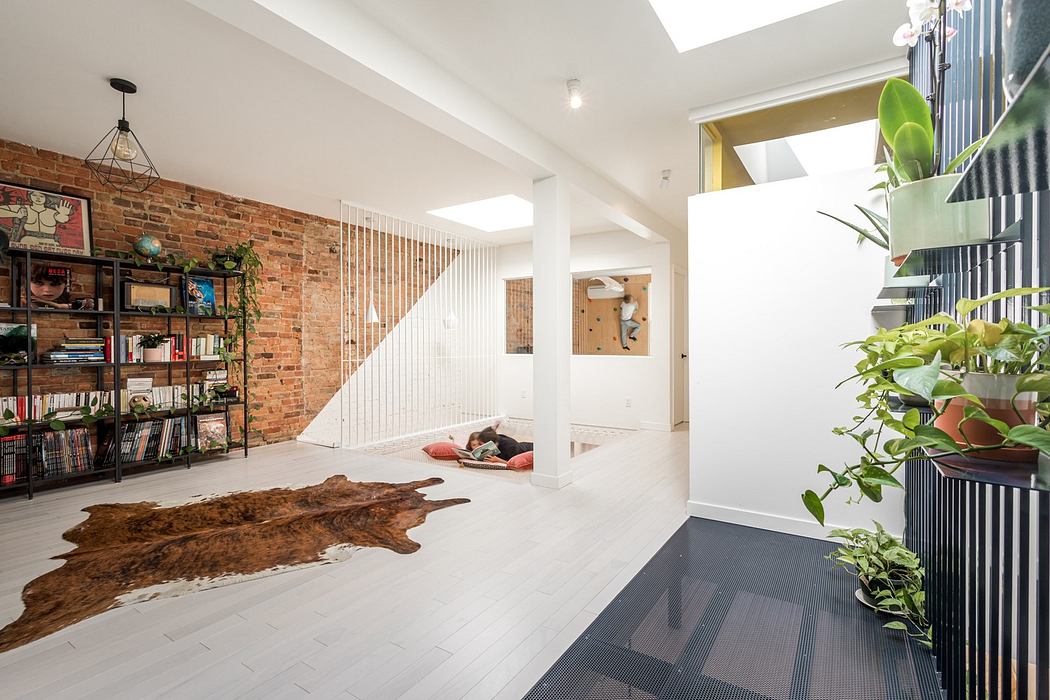 Modern interior with exposed brick, white walls, wooden floors, and green plants.
