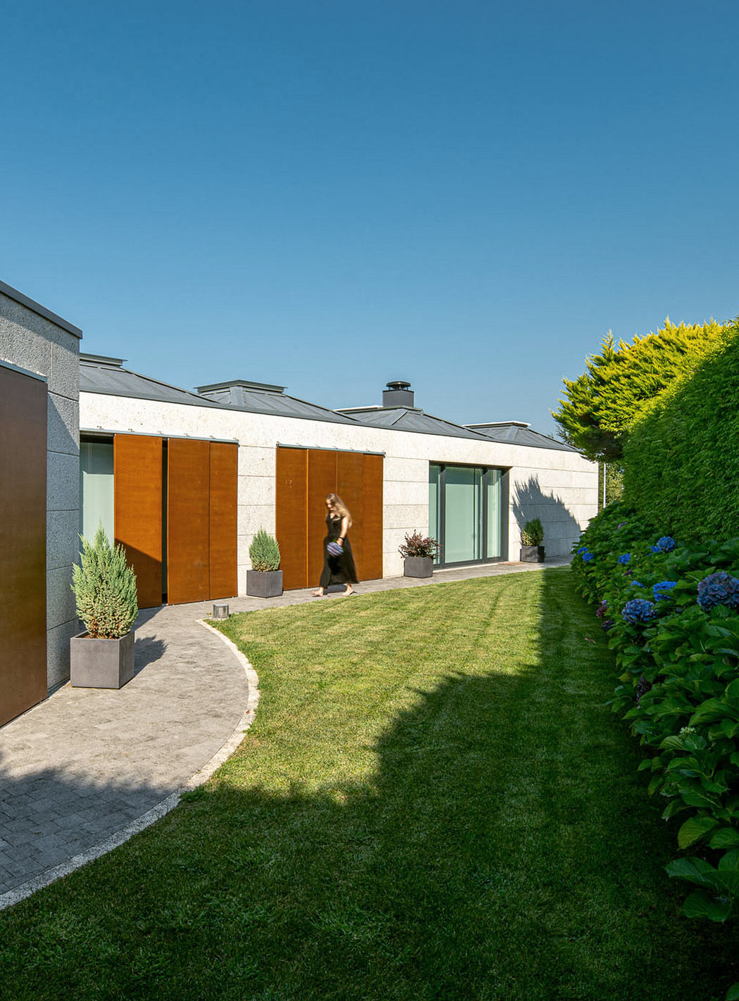 Modern house exterior with a manicured lawn and garden path.