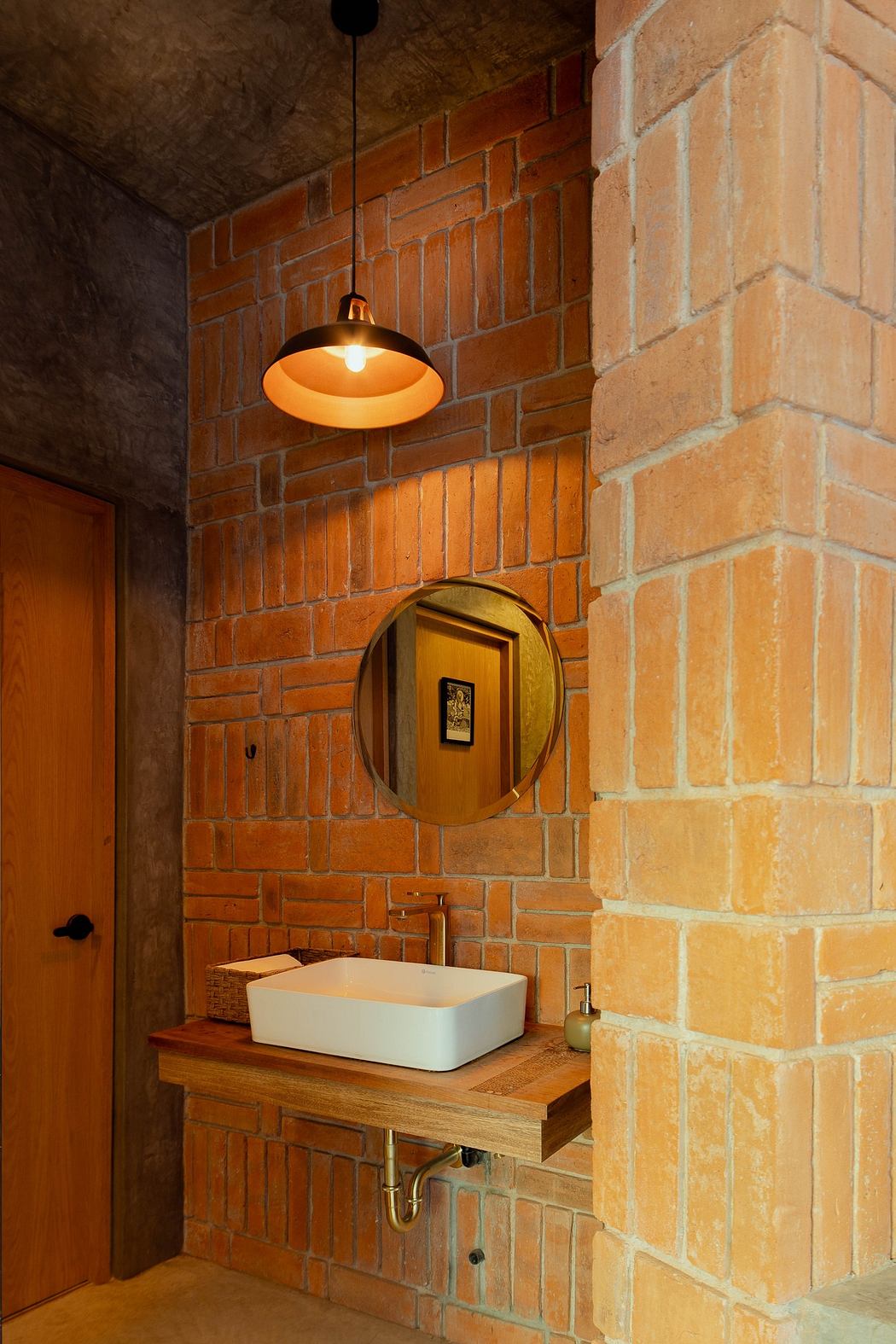 Modern bathroom with exposed brick walls and wooden vanity.
