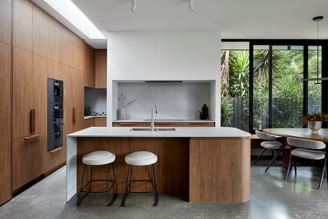 Modern kitchen with wooden cabinets, island with stools, and a view of greenery