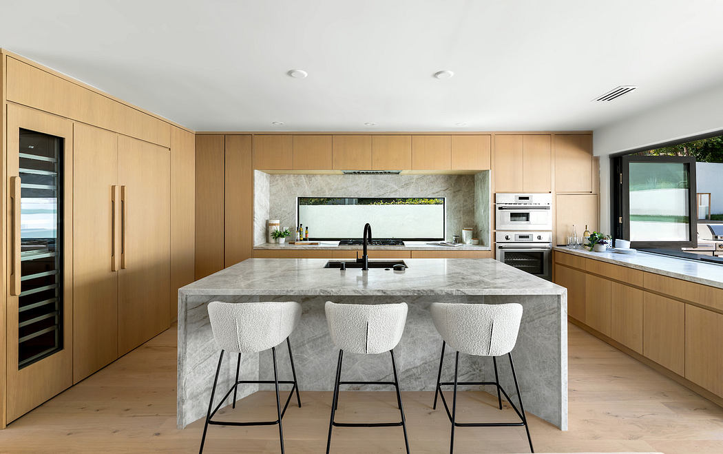 Modern kitchen interior with marble island and wooden cabinetry.