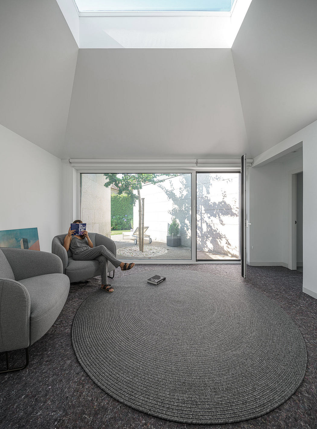 Modern minimalist living room with large window and skylight.