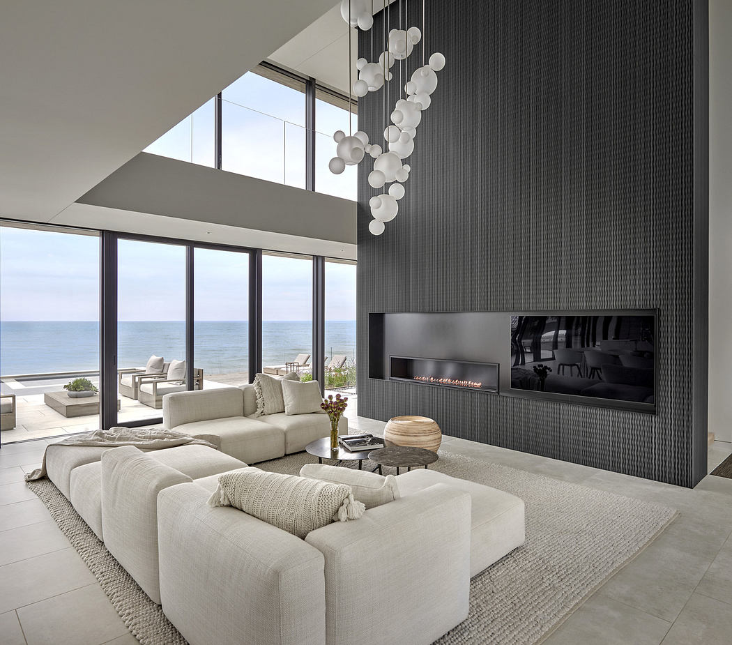 Modern living room with ocean view, sectional sofa, and fireplace.