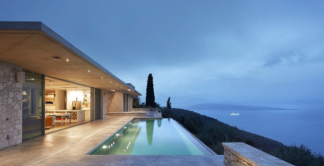 Modern house with infinity pool overlooking the sea at dusk.