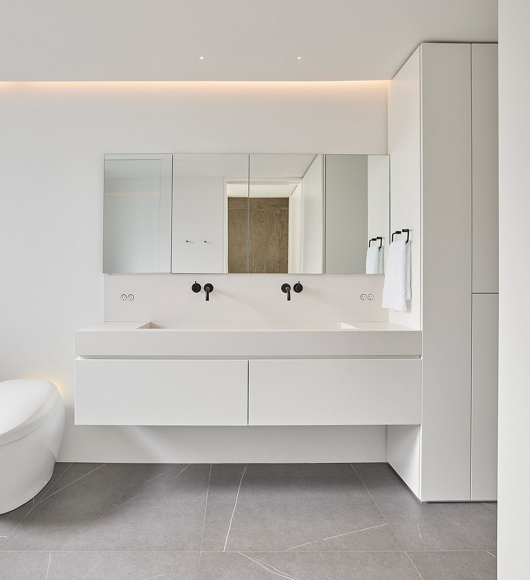 Modern bathroom with double vanity, wall mirror, and minimalist design.